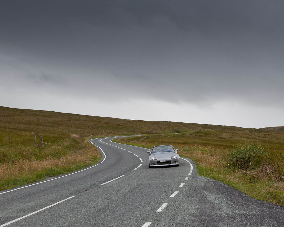 A sports car on a winding open UK road